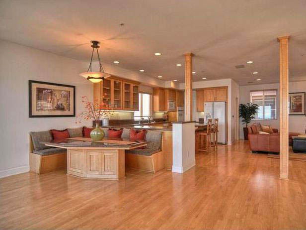 Bright open kitchen space with breakfast nook, wood floors and cabinets in a warm setting