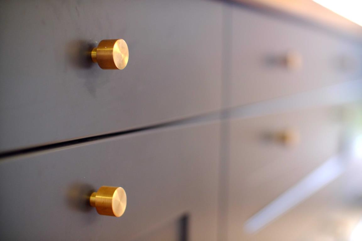 gray-blue cabinets with brass handles on drawers